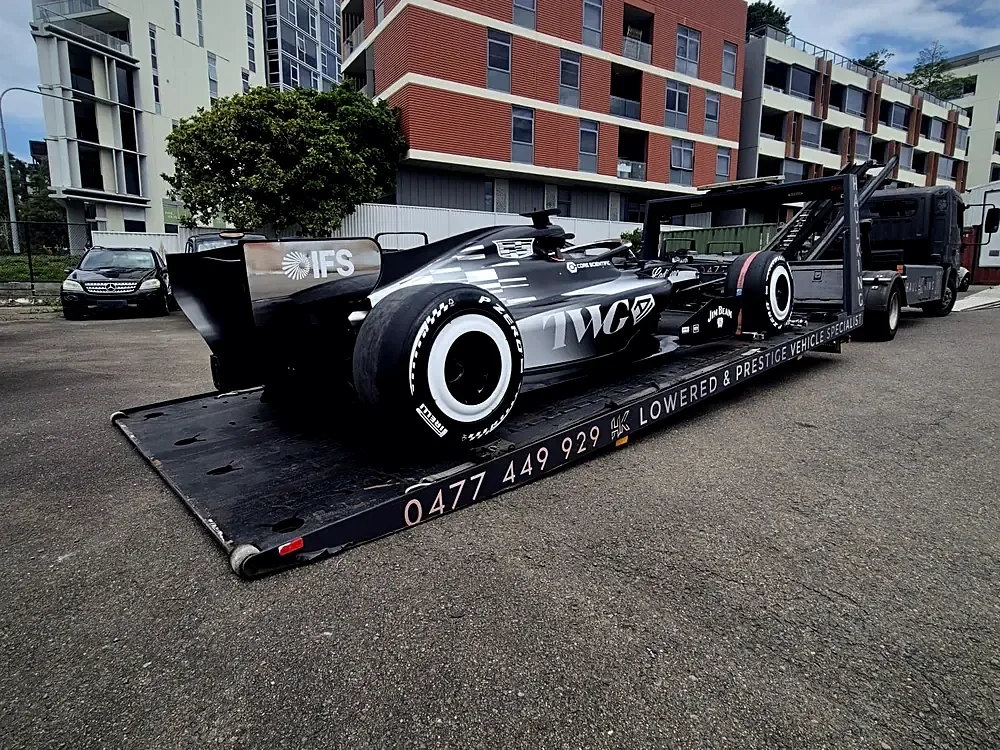 Single-seater race car loaded flat on Haul King's low-angle tray